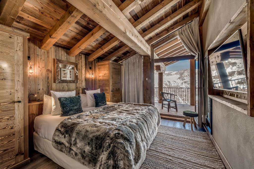 une chambre avec un grand lit et un balcon dans l'établissement Le Refuge de Solaise - 2551 m Altitude, à Val dʼIsère