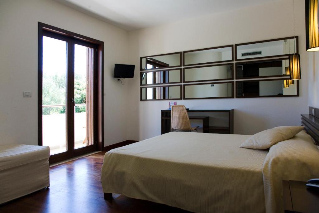 une chambre avec un lit, un bureau et une fenêtre dans l'établissement Hotel Le Piane, à Villammare