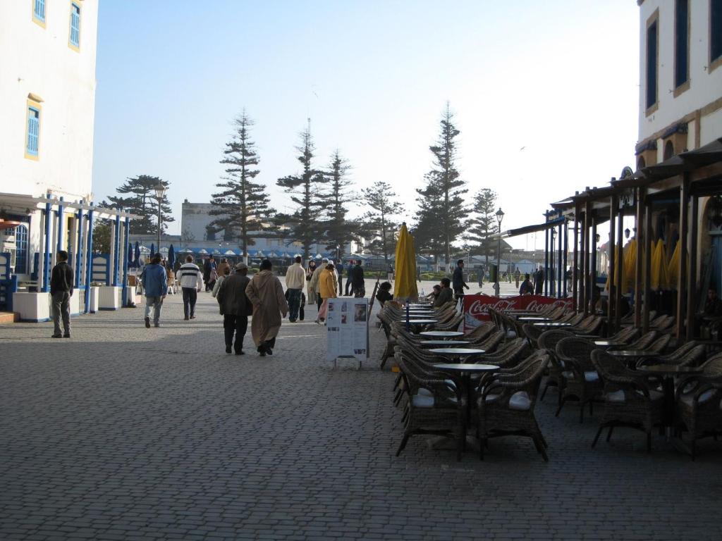 un groupe de personnes marchant sur un trottoir avec des tables et des chaises dans l'établissement Dar Ness, à Essaouira 30 autres photos