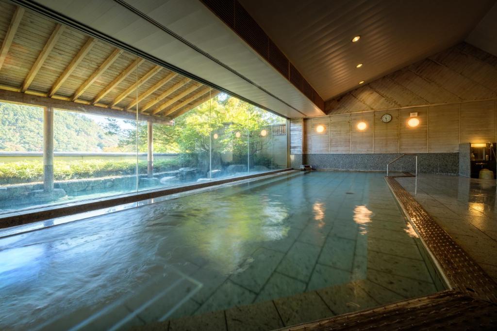 - une piscine vide dans un bâtiment avec une grande fenêtre dans l'établissement Iizaka Onsen Surikamitei Ohtori, à Fukushima