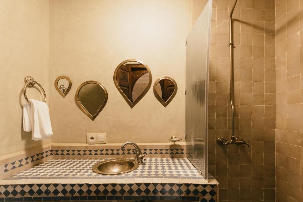 une salle de bain avec un lavabo et une douche avec miroirs dans l'établissement L'Emeraude de la Médina, à Marrakech