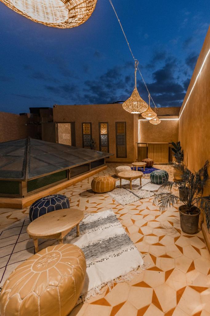 un patio avec des tables et des chaises dans un bâtiment dans l'établissement L'Emeraude de la Médina, à Marrakech