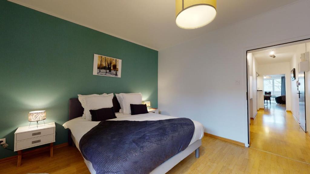 une chambre avec un grand lit et un mur végétal dans l'établissement Le Nid Cosy + 1 Garage, à Colmar