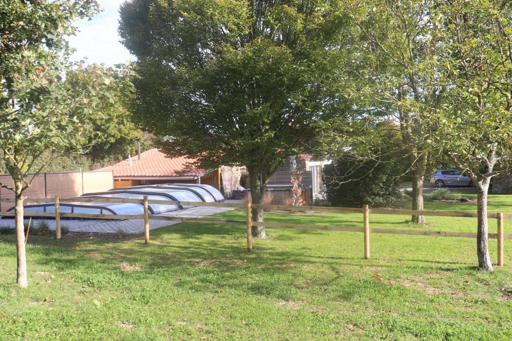 un groupe d'arbres dans une cour avec un parking dans l'établissement Gîte avec piscine ,près de Chantonnay, à Saint-Germain-de-Prinçay