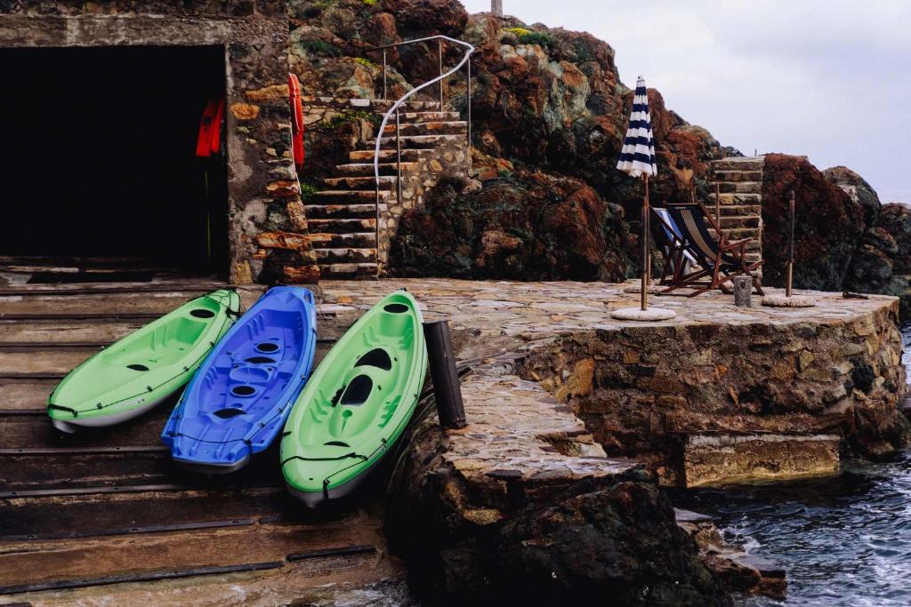 un groupe de trois kayaks assis sur des marches près de l'eau dans l'établissement Residence Intur, à Marciana Marina 210 autres photos