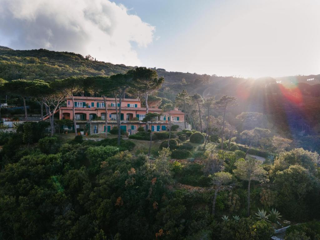 une maison sur une colline avec un arc-en-ciel dans le ciel dans l'établissement Residence Intur, à Marciana Marina