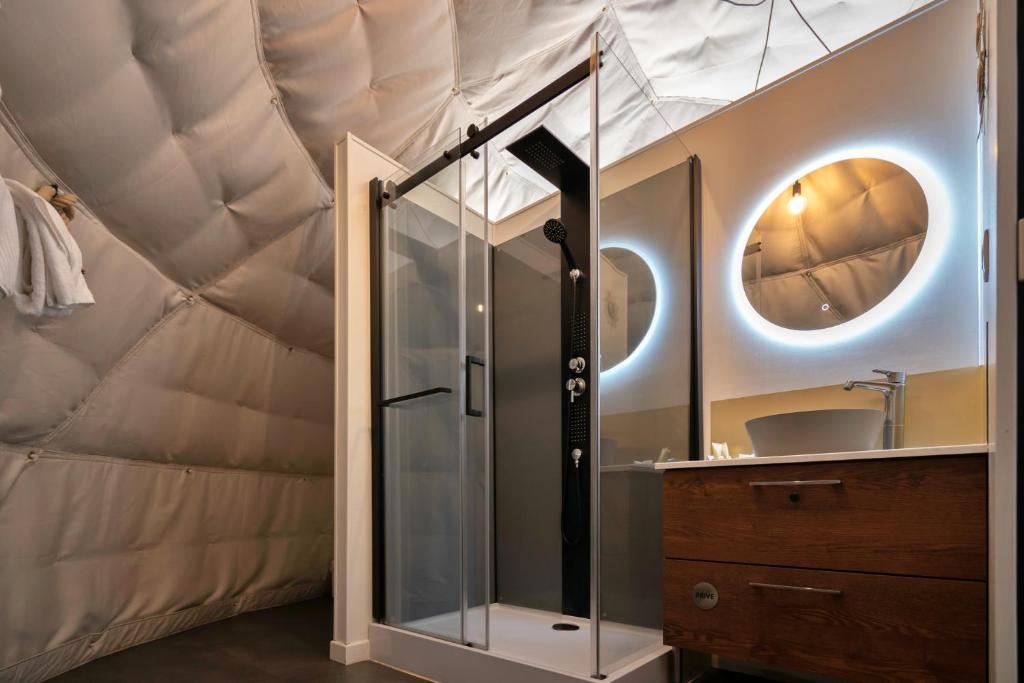 - une salle de bains pourvue d'une douche en verre dans une tente dans l'établissement Au Champ de l'Insolite, à Miers