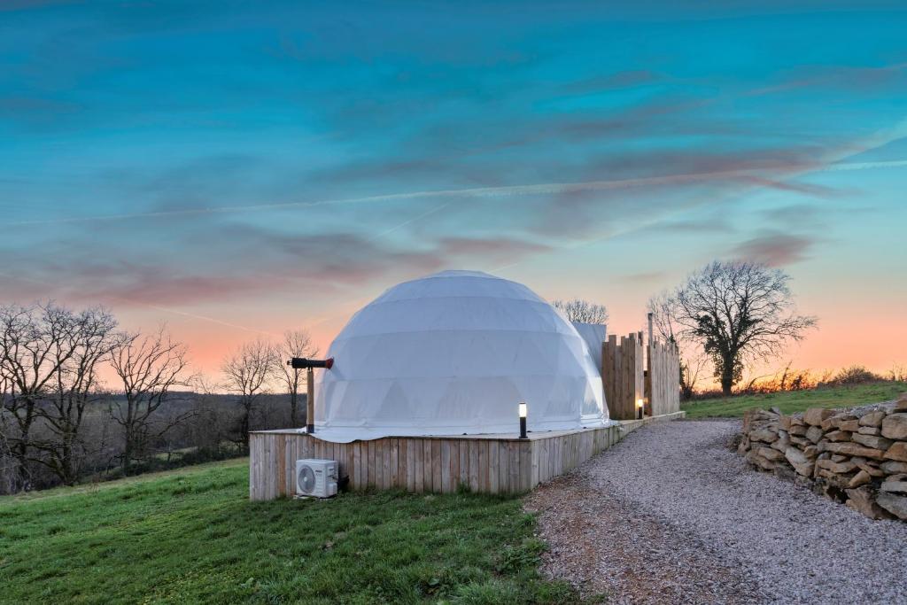 un observatoire dôme sur une colline avec un coucher de soleil dans l'établissement Au Champ de l'Insolite, à Miers