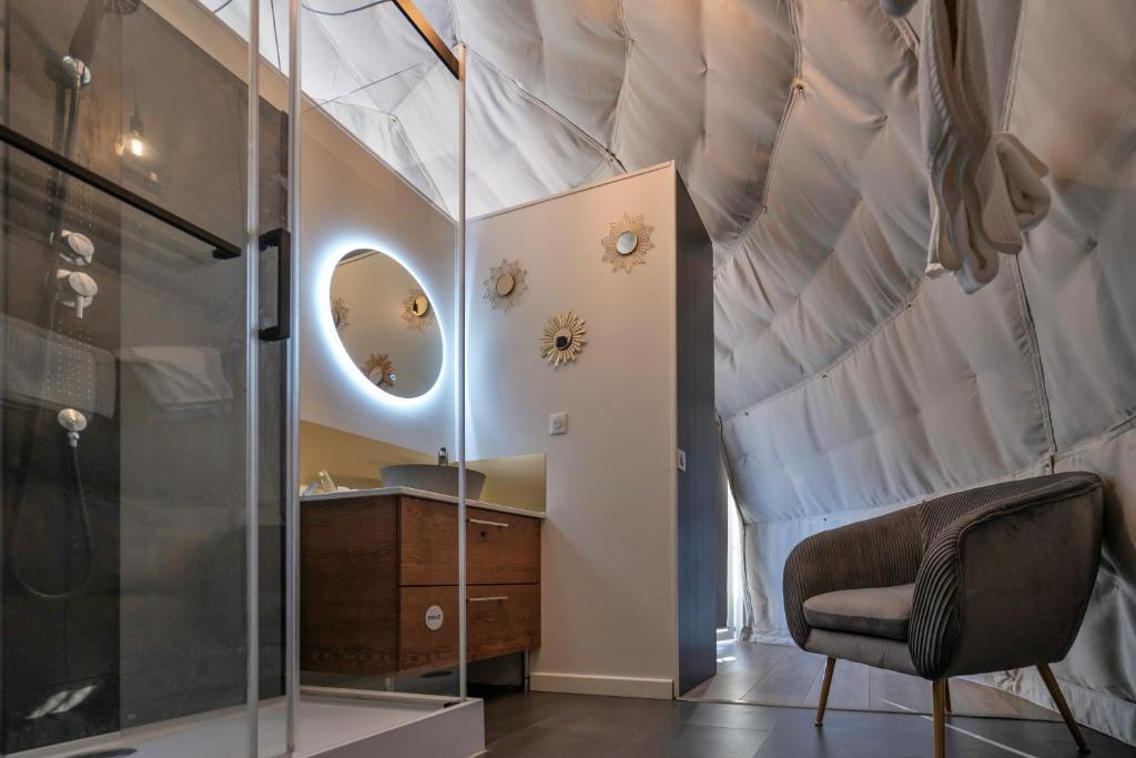 une chambre avec un lit avec un miroir et une chaise dans l'établissement Au Champ de l'Insolite, à Miers