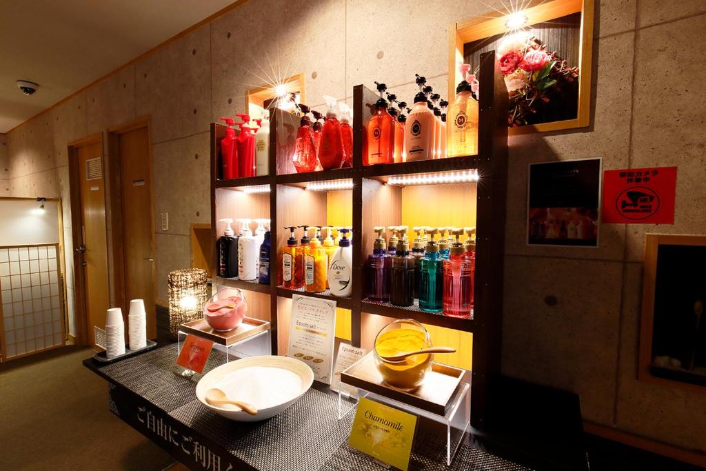 une chambre avec un bouquet de bouteilles sur une étagère dans l'établissement 隠家（ajito）HOTEL555 小田原店, à Kami-soga 9 autres photos