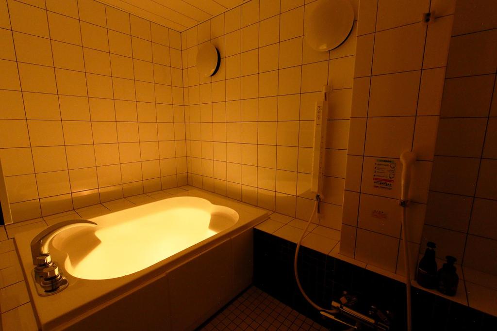 une salle de bain avec une baignoire et un lavabo dans l'établissement 隠家（ajito）HOTEL555 小田原店, à Kami-soga