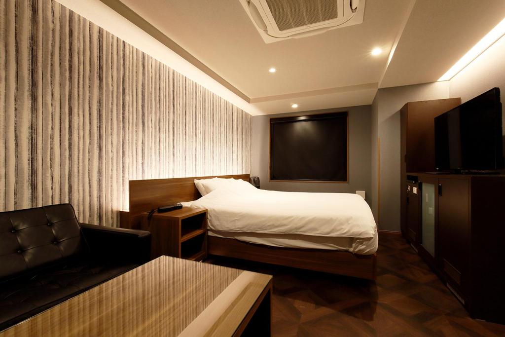 une chambre d'hôtel avec un lit et une télévision dans l'établissement KNOWS HOTEL, à Numazu 18 autres photos