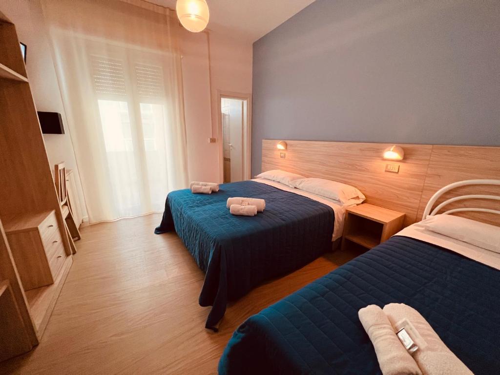 une chambre d'hôtel avec deux lits avec des serviettes dessus dans l'établissement Hotel Damma's, Dipendenza Zamagna, à Cesenatico