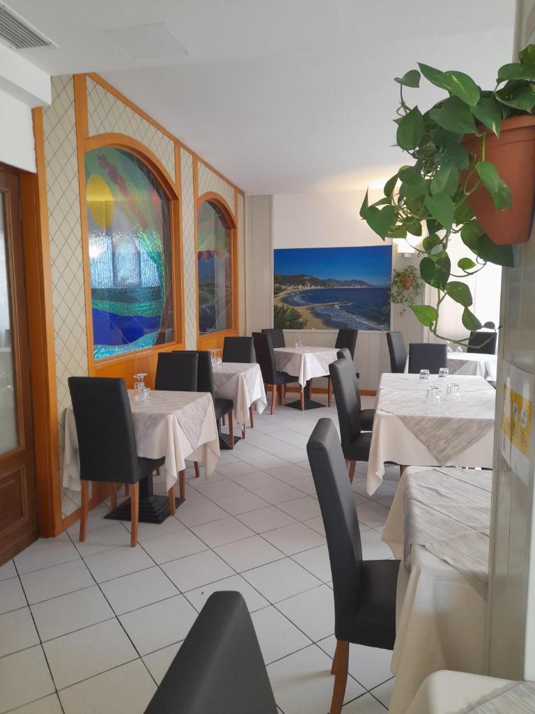 un restaurant avec des tables et des chaises et une plante en pot dans l'établissement Hotel Gilda, à Laigueglia