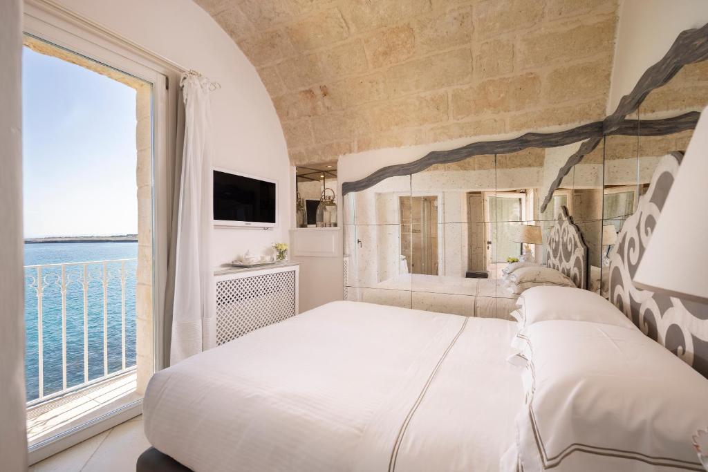 une chambre avec un grand lit et une grande fenêtre dans l'établissement Hotel Don Ferrante, à Monopoli 105 autres photos