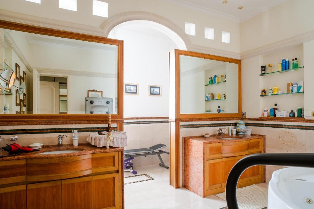 une salle de bain avec deux lavabos et un grand miroir dans l'établissement Palazzo P D'ajmo - Dimora Storica, à Lecce
