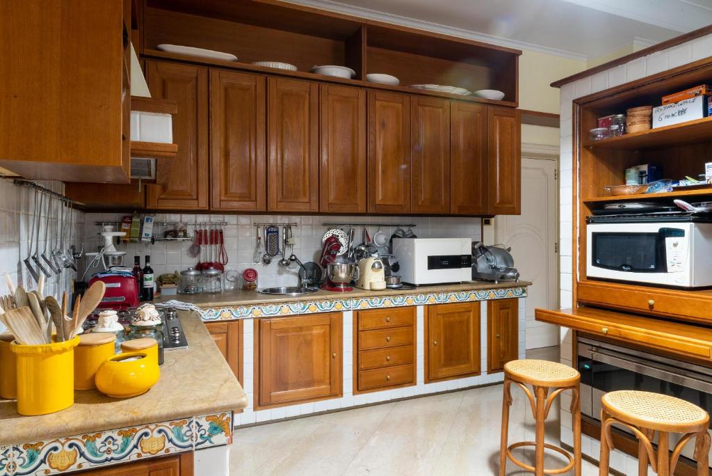 une cuisine avec des armoires et des comptoirs en bois dans l'établissement Palazzo P D'ajmo - Dimora Storica, à Lecce