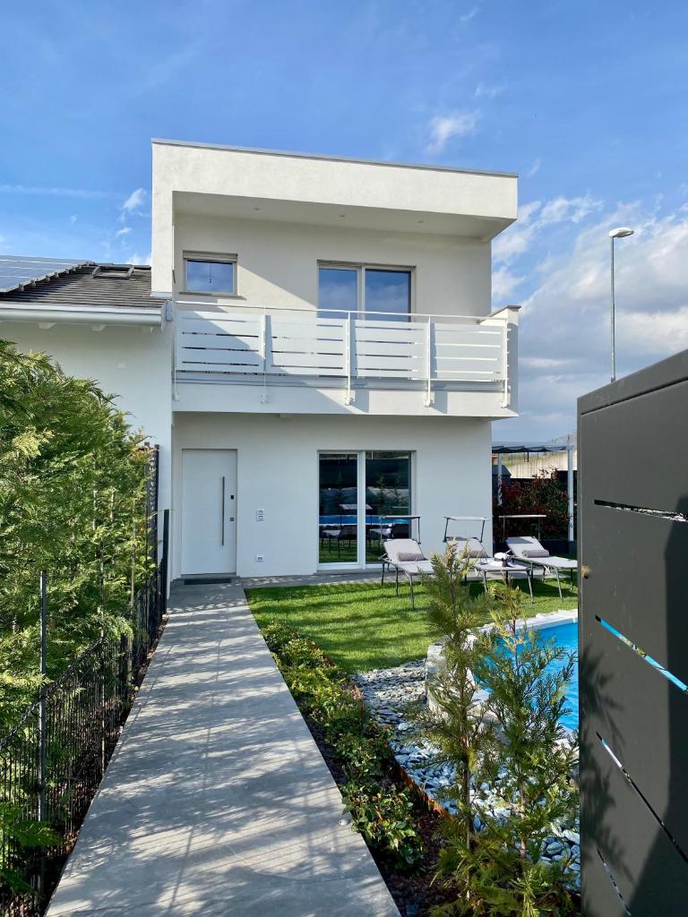 Cette maison blanche dispose d'un balcon et d'une cour. dans l'établissement Villa Carlotta, à Salionze