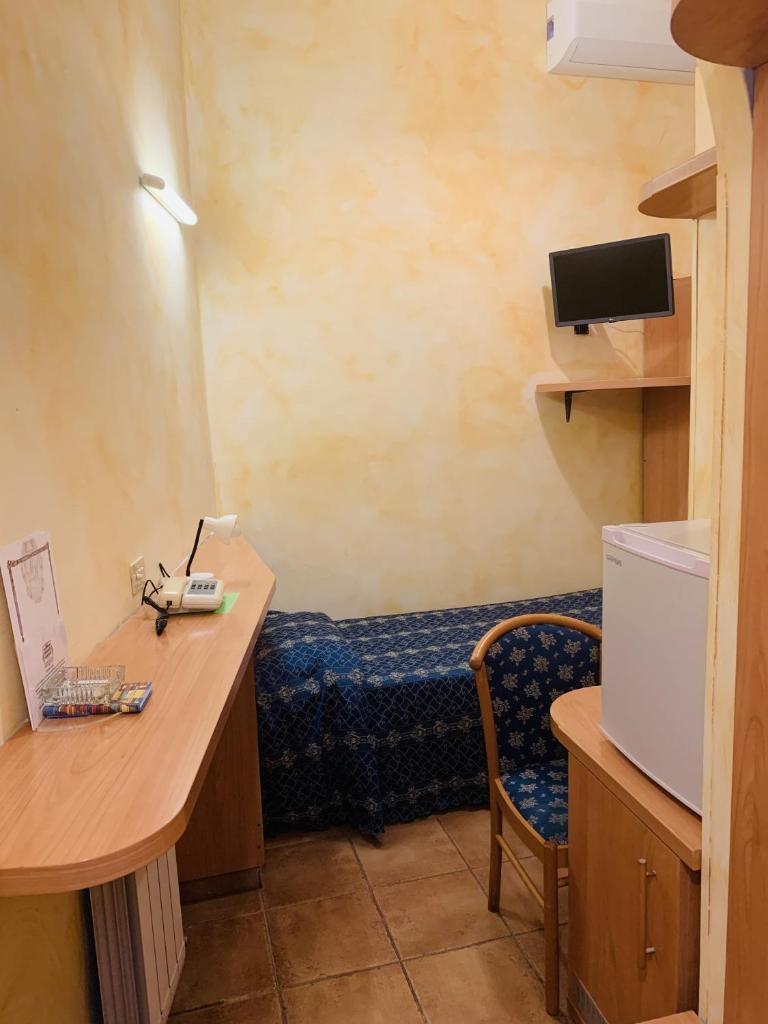 Cette chambre comprend un bureau et un lit. dans l'établissement Hotel Miramare, à Ladispoli