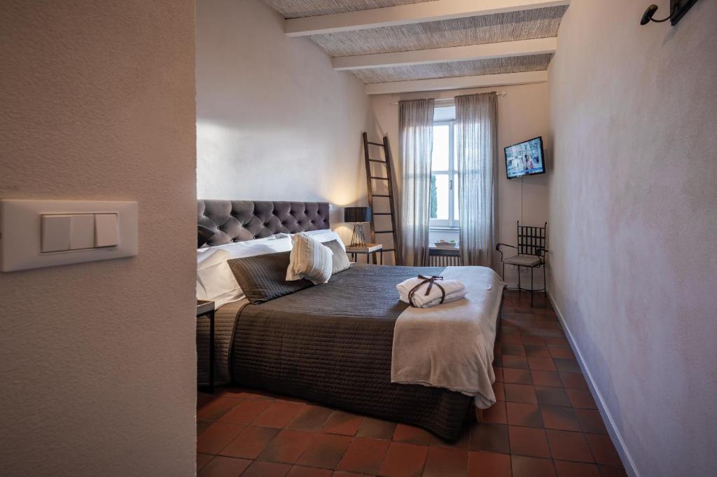 une chambre avec un grand lit dans une pièce dans l'établissement Locanda Antica Osteria Saracena del Bergallo, à Borgio Verezzi