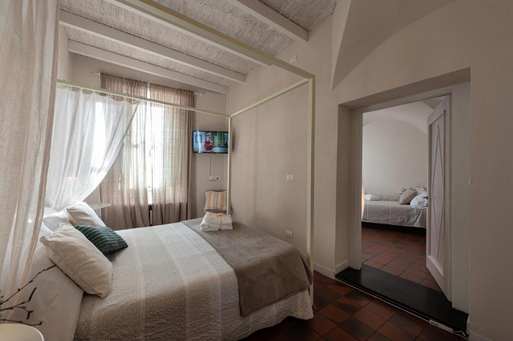 une chambre avec un grand lit et un miroir dans l'établissement Locanda Antica Osteria Saracena del Bergallo, à Borgio Verezzi