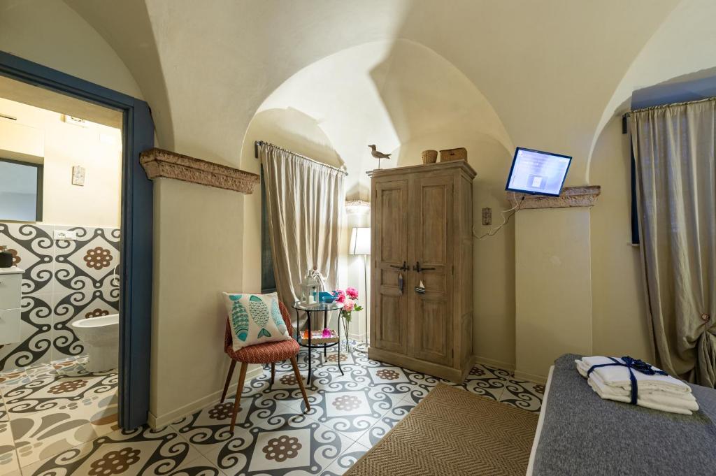 Cette chambre comprend un lit, une table et une porte. dans l'établissement Locanda Antica Osteria Saracena del Bergallo, à Borgio Verezzi