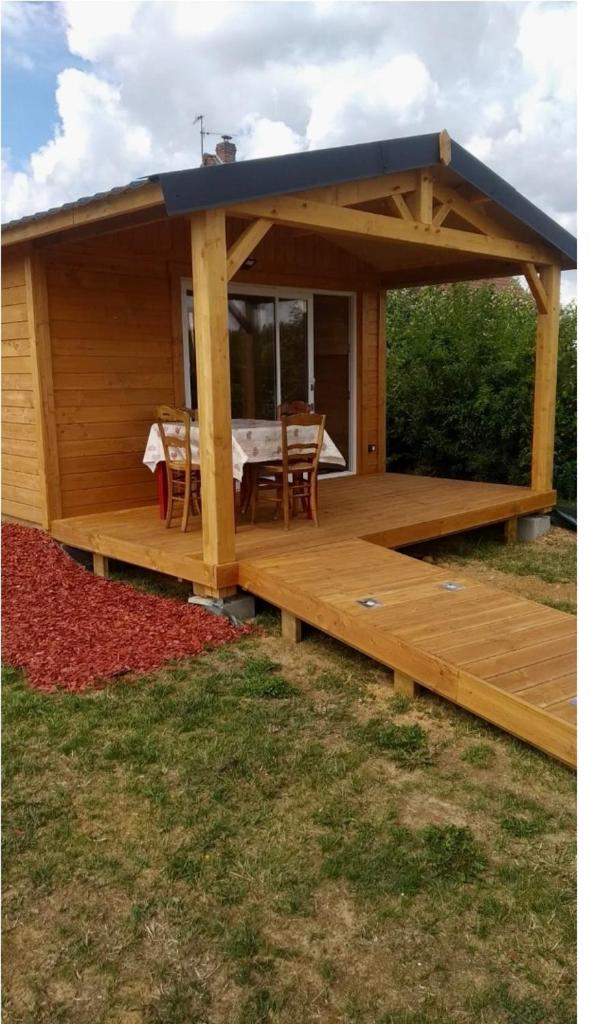 Cette cabine dispose d'une terrasse en bois avec une table. dans l'établissement Yourte A bourlon, à Bourlon 9 autres photos