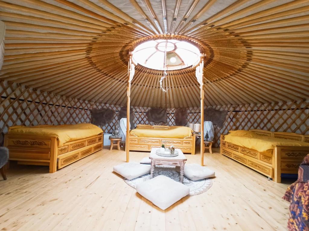 - une chambre avec 2 lits et une table dans une yourte dans l'établissement Yourte A bourlon, à Bourlon
