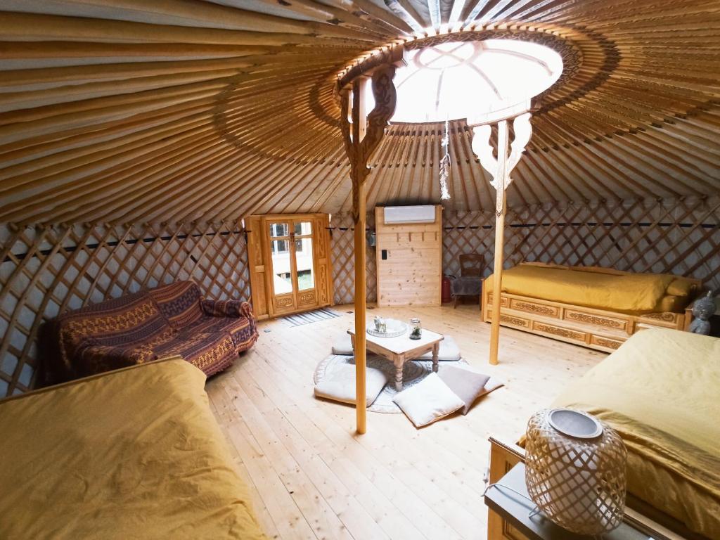 Cette chambre comprend une yourte avec un canapé et une table. dans l'établissement Yourte A bourlon, à Bourlon