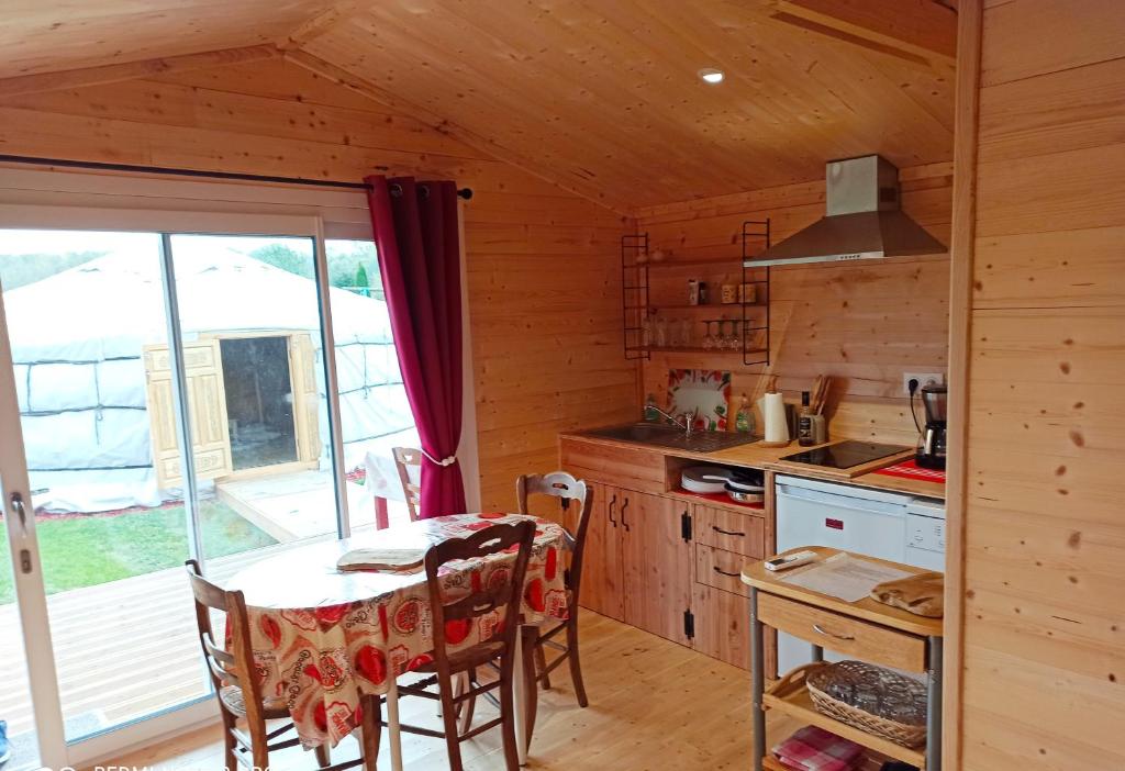 une cuisine avec une table dans une cabine dans l'établissement Yourte A bourlon, à Bourlon