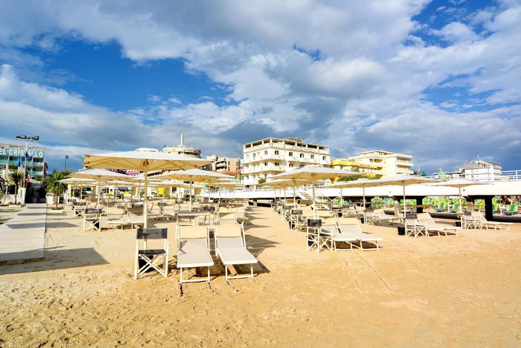 un groupe de chaises et de parasols sur une plage dans l'établissement Terrazza Marconi Hotel&Spamarine, à Senigallia