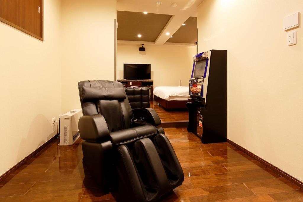 une chambre avec un fauteuil inclinable noir dans l'établissement HOTEL 555 Air, à Higashine