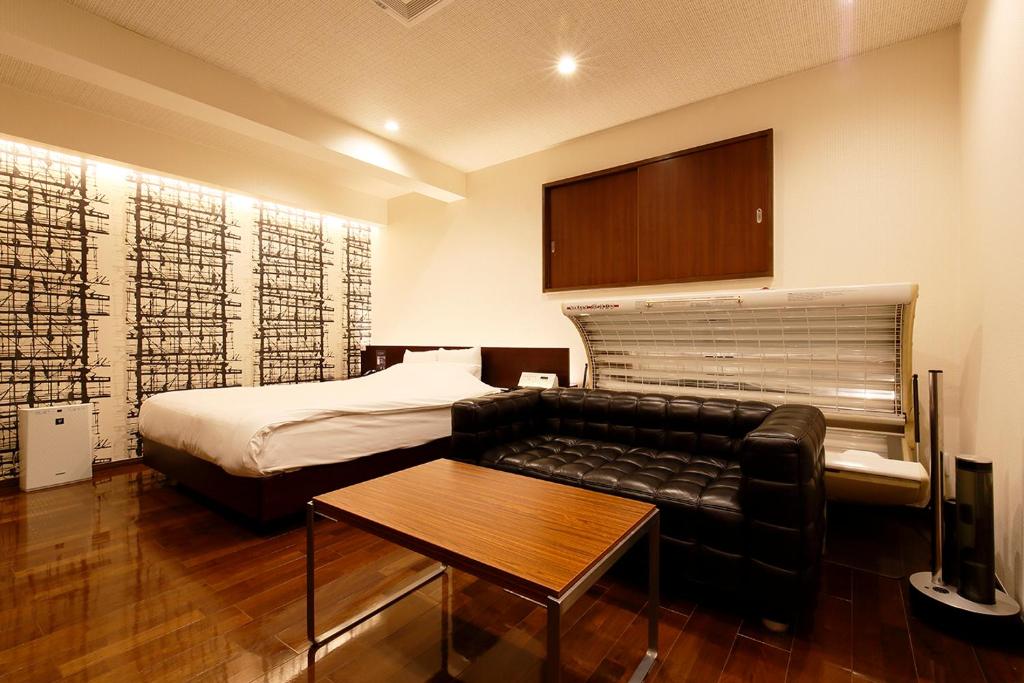 une chambre avec un lit, un canapé et une table dans l'établissement HOTEL 555 Air, à Higashine