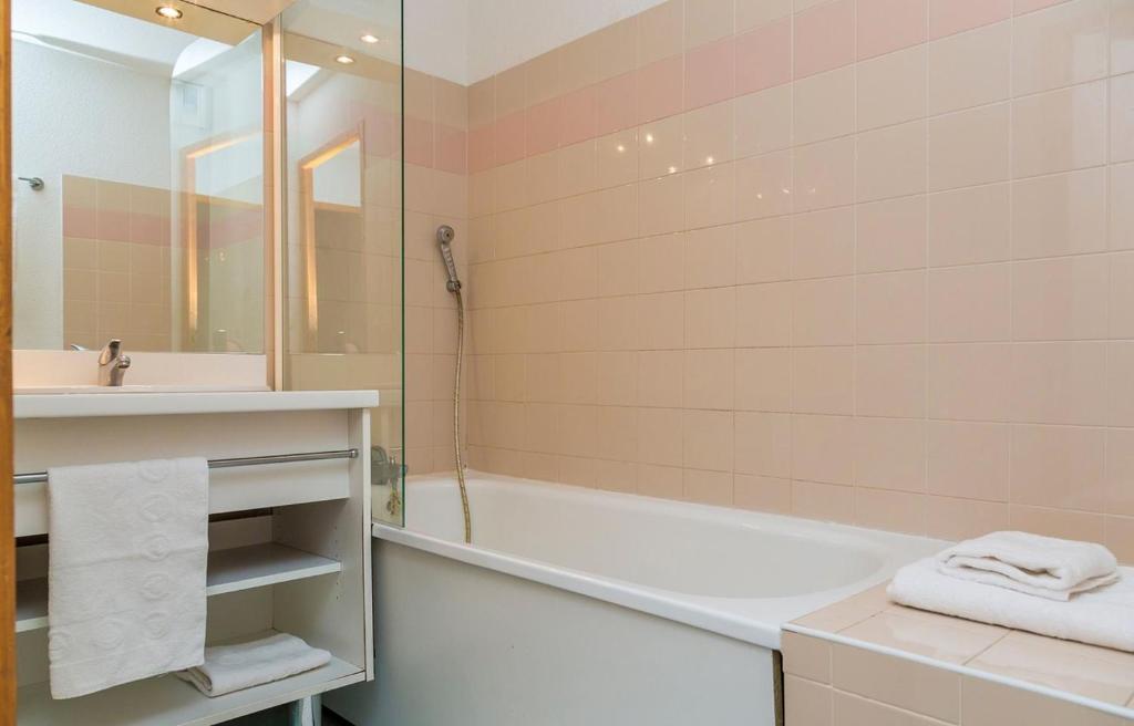 La salle de bains est pourvue d'une baignoire, d'un lavabo et d'une baignoire. dans l'établissement Appartement 42M² pour 4/6 personnes à VALMEINIER 1800, à Valmeinier