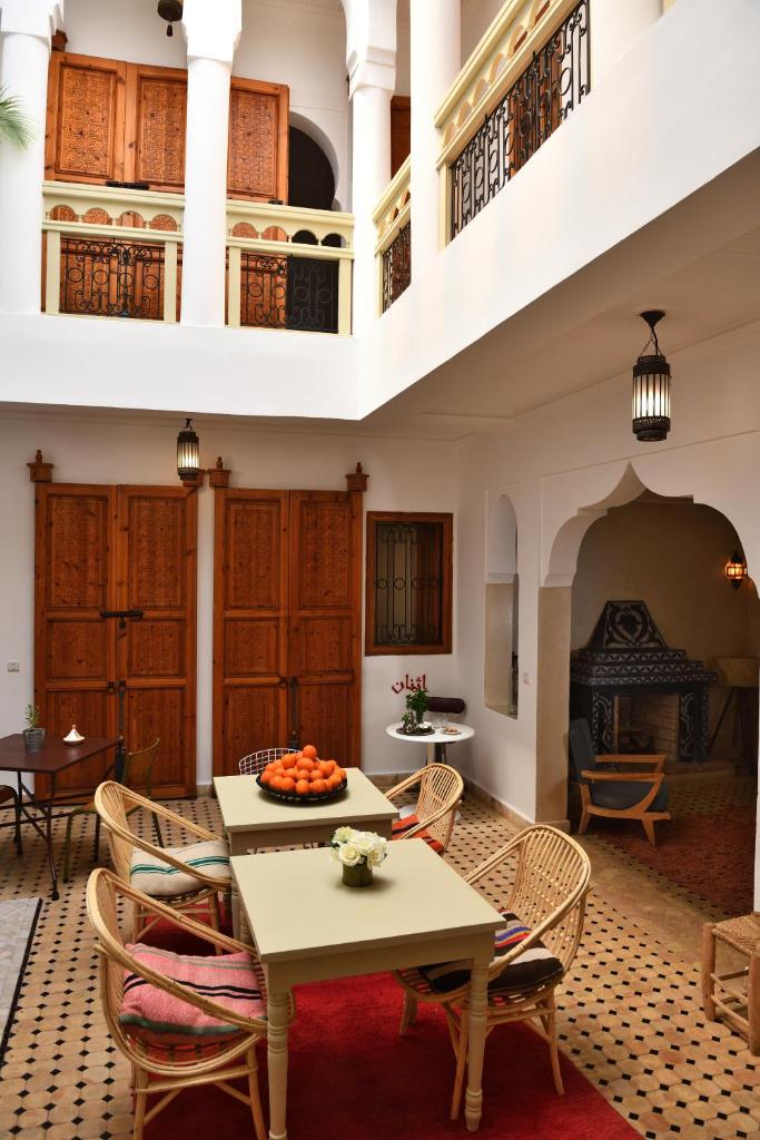 un salon avec une table et des chaises et une cheminée dans l'établissement Riad Lamzia, à Marrakech