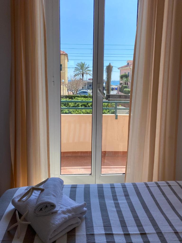 une chambre avec un lit et une fenêtre avec vue dans l'établissement Hotel Villa Paolina, à Pietra Ligure