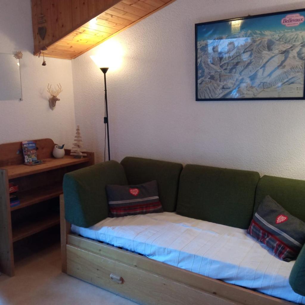 un canapé avec des coussins dessus dans un salon dans l'établissement Appartement dernier étage au pied des pistes HIRMENTAZ, à Bellevaux