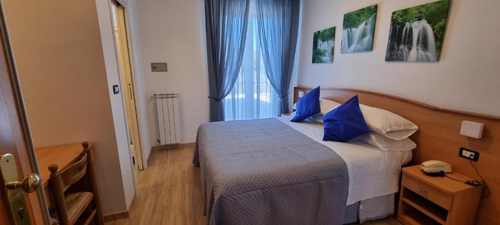 une chambre avec un lit avec des oreillers bleus dans l'établissement Hotel Mare Blu -- boutique, à Pineto