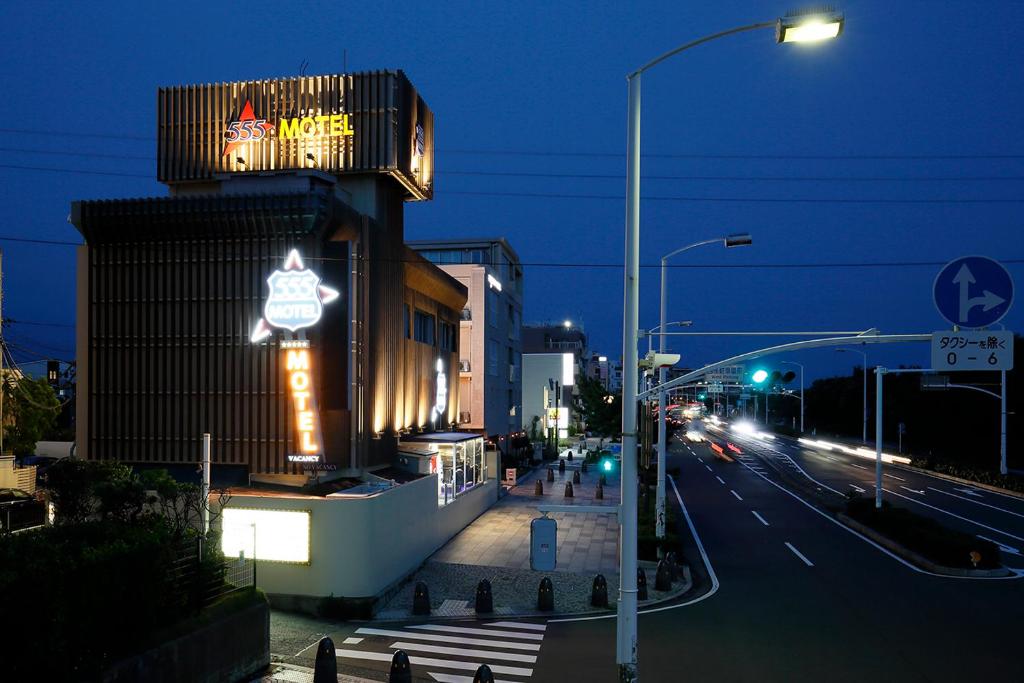 un bâtiment avec une enseigne sur le côté d'une rue dans l'établissement 555MOTEL SHONAN, à Fujisawa