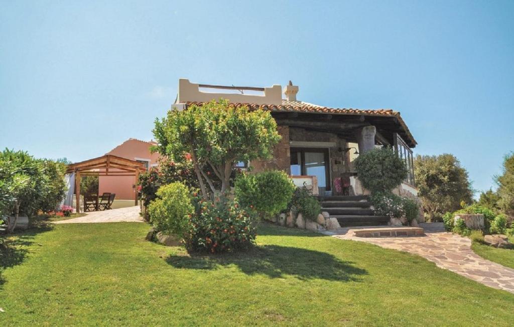 une maison avec une cour gazonnée avec une maison dans l'établissement Eduard Villa, à Stintino