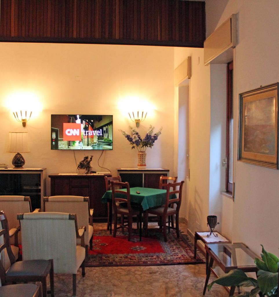 un salon avec une table et une télévision dans l'établissement Hotel Mediterranée, à Taormine