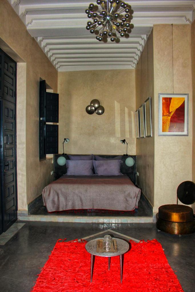 - une chambre avec un grand lit et un tapis rouge dans l'établissement Riad Heva, à Marrakech
