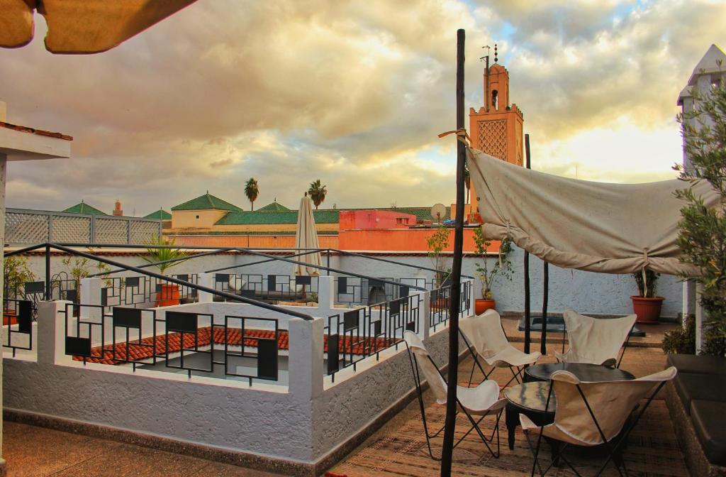 - un balcon avec des chaises et un hamac dans un bâtiment dans l'établissement Riad Heva, à Marrakech