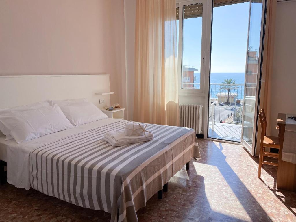 une chambre d'hôtel avec un lit et une grande fenêtre dans l'établissement Hotel Villa Paolina, à Pietra Ligure