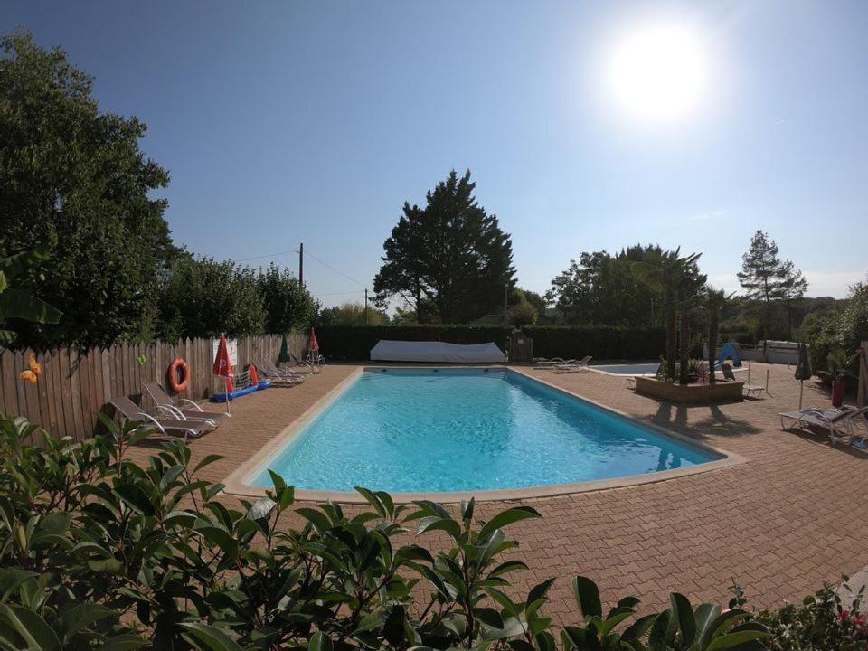 - une piscine dans une cour avec des chaises et une clôture dans l'établissement Camping maeva Escapades Au P'tit Bonheur, à Peyrillac-et-Millac 30 autres photos