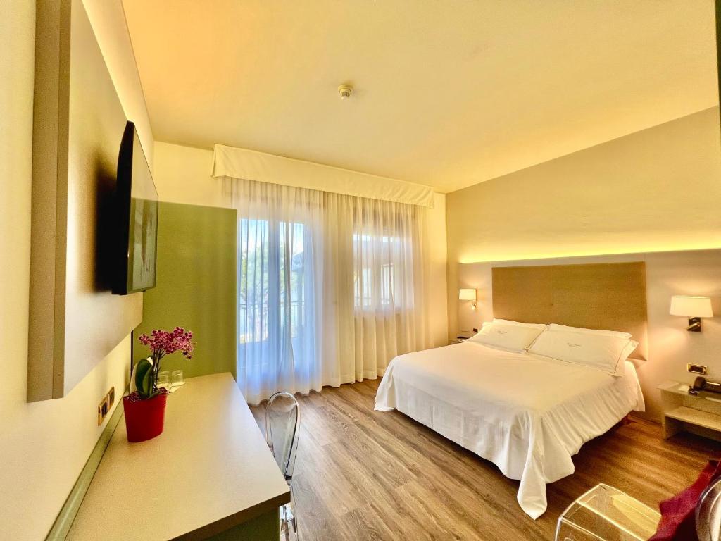 une chambre avec un lit blanc et une fenêtre dans l'établissement Hotel Marina, à Viverone