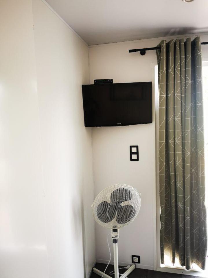 Cette chambre dispose d'un ventilateur et d'une télévision murale. dans l'établissement Mobil home 8 personnes camping l ile d or saint raphael, à Saint-Raphaël