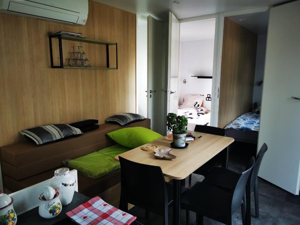 un salon avec une table et un canapé dans l'établissement Mobil home 8 personnes camping l ile d or saint raphael, à Saint-Raphaël
