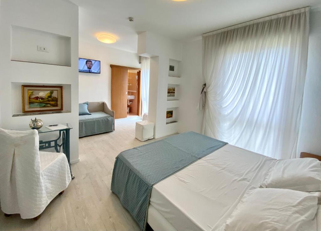 une chambre avec un lit et un canapé dans une pièce dans l'établissement Hotel Cavallino Bianco, à Cavallino-Treporti