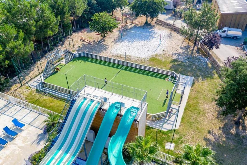 - une vue aérienne sur un court de tennis avec deux chaises bleues dans l'établissement Mobil-home spatieux 8pers - BRUME, à Saint-Julien-en-Born
